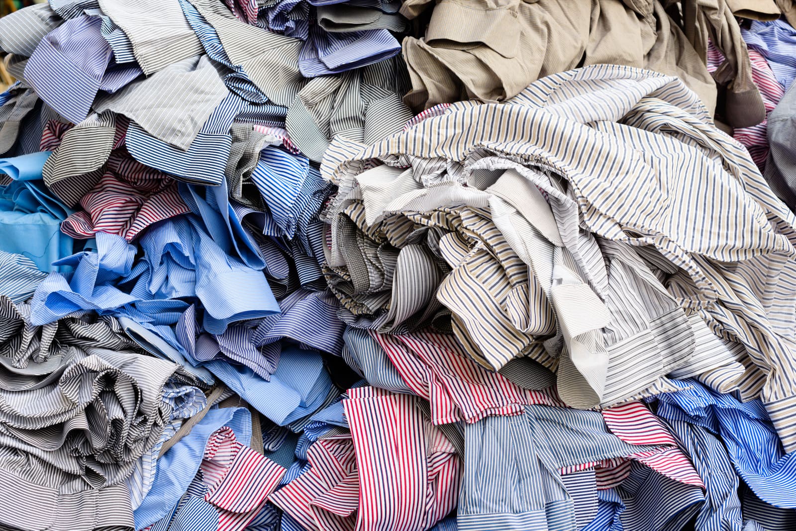 Stacked unfinished shirts, supply-chain context.